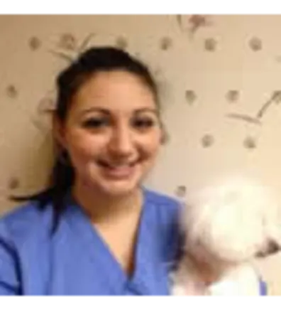 Maria Gatto's staff photo from Shinnecock Animal Hospital where she posing with a white dog in her arms.